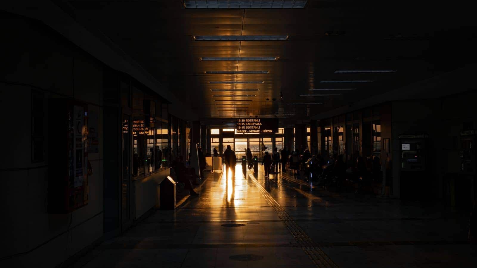 Terminal de aeropuerto con horizonte urbano al atardecer